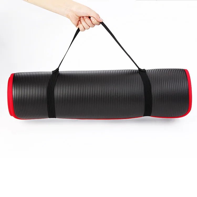 Black and red yoga mat with carrying straps on a white background