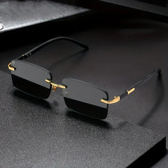 Black rimless sunglasses with gold accents on a dark textured surface