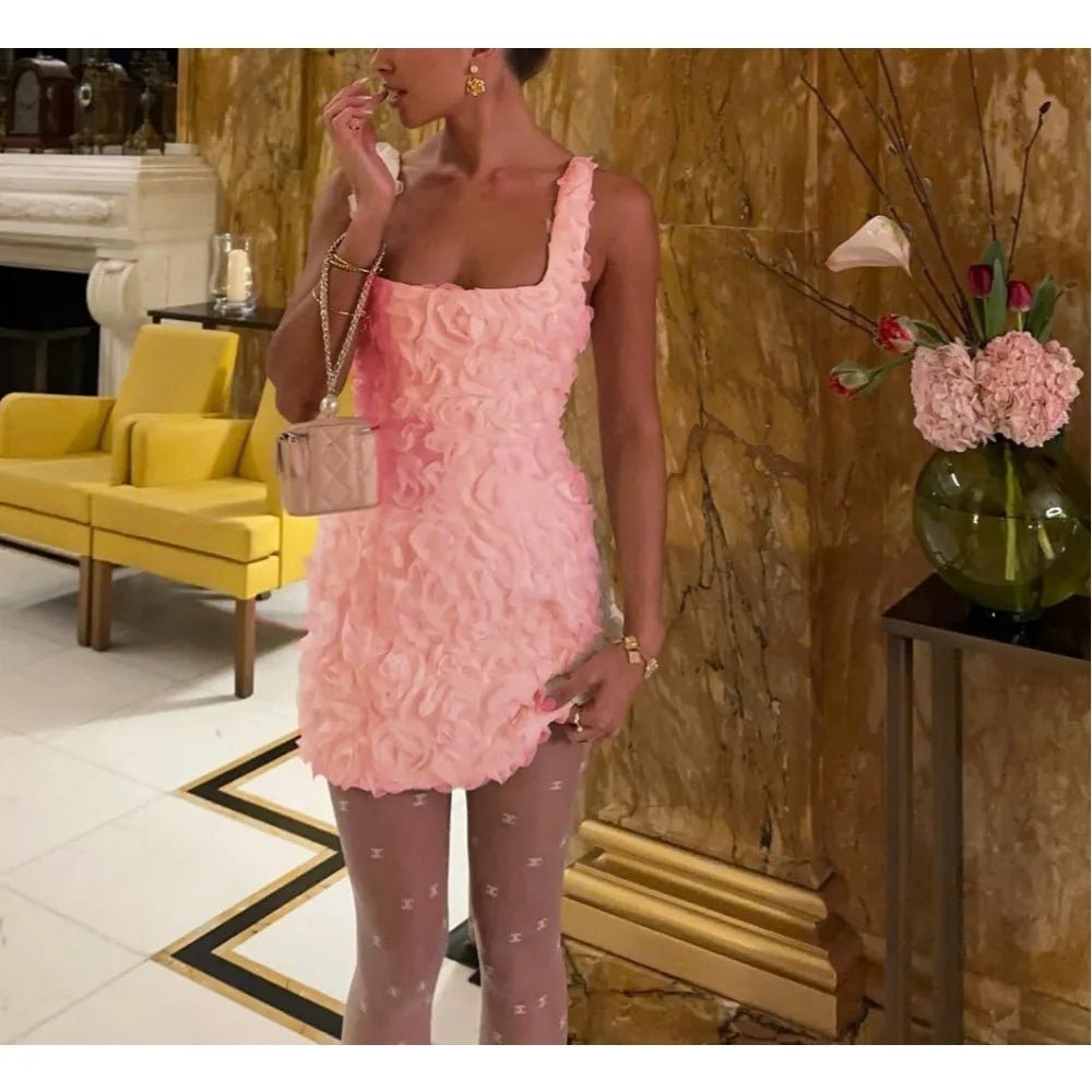 Woman in a pink dress standing in an elegant room with yellow furniture and floral decorations.