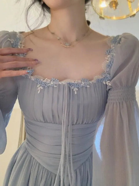 Light blue dress with floral embellishments on a neutral background