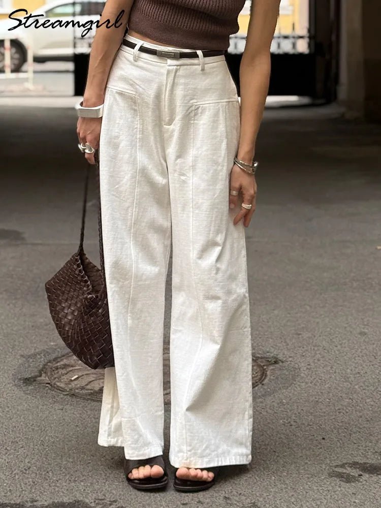 Person wearing white wide-leg pants on a street.