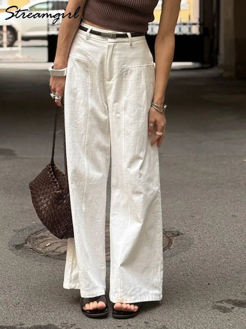 Person wearing white wide-leg pants on a street.