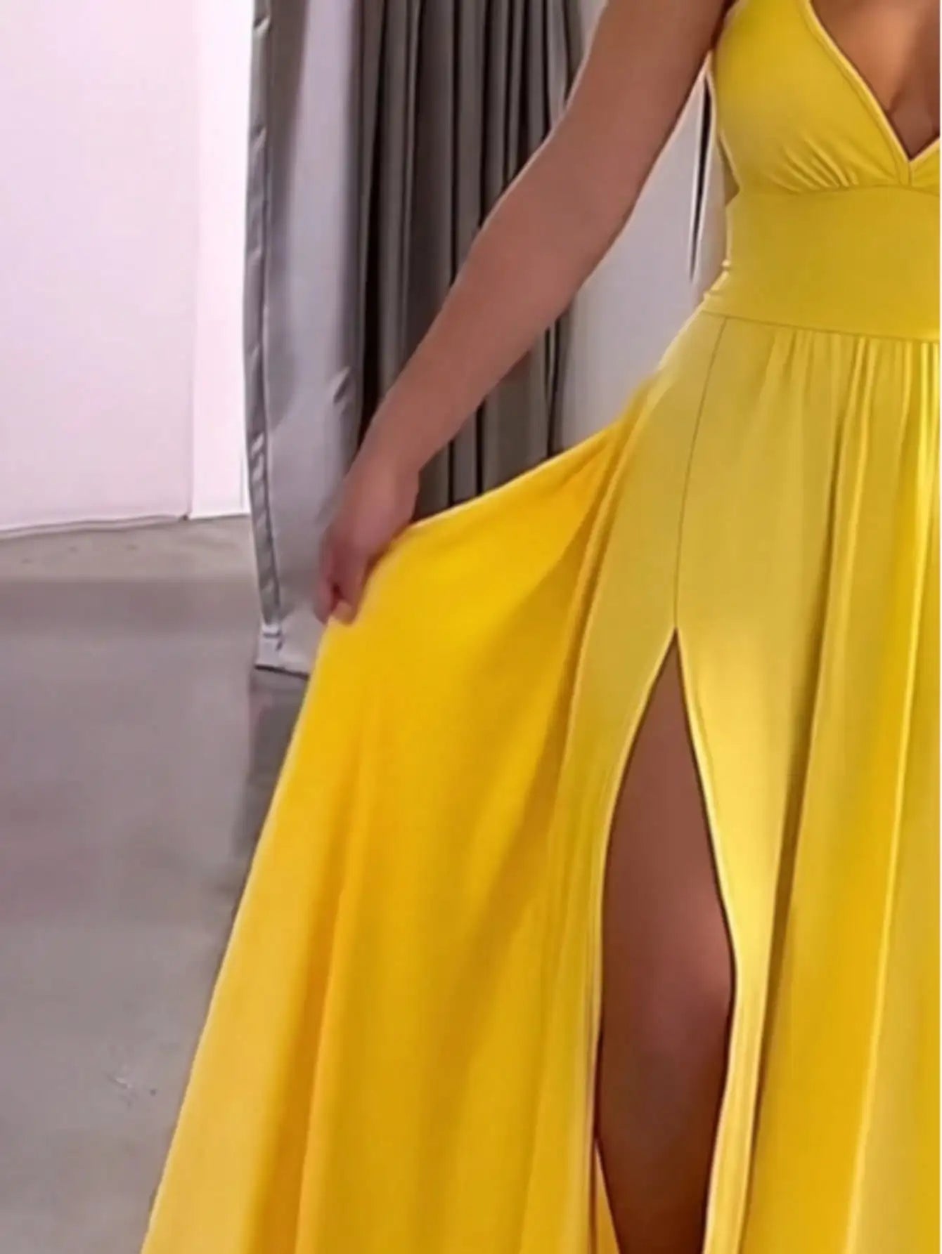 Yellow dress with a high slit on a neutral background