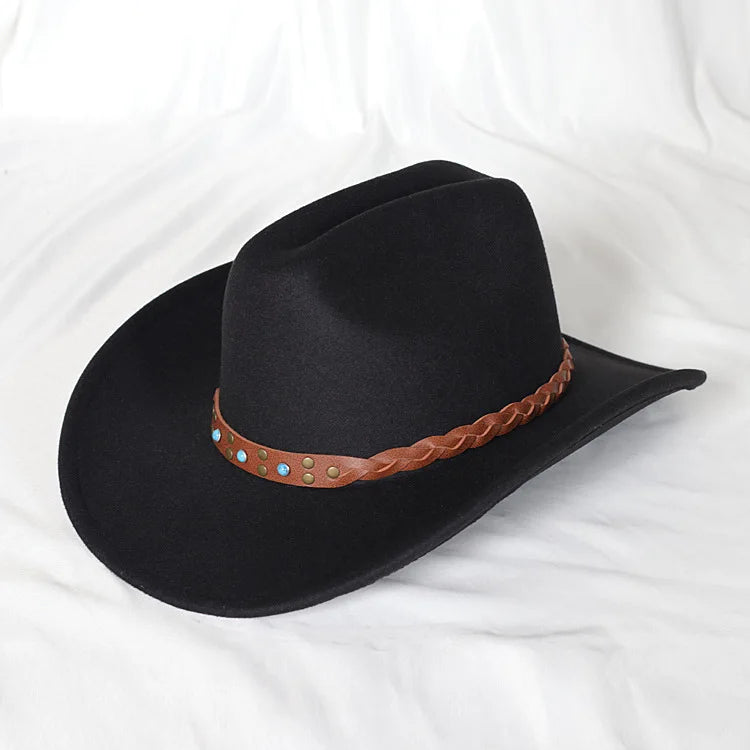 Black cowboy hat with a brown braided band on a white fabric background