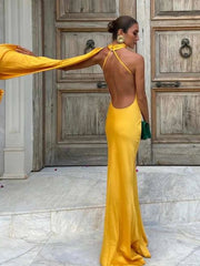 Woman in a yellow evening gown standing in front of a wooden door.