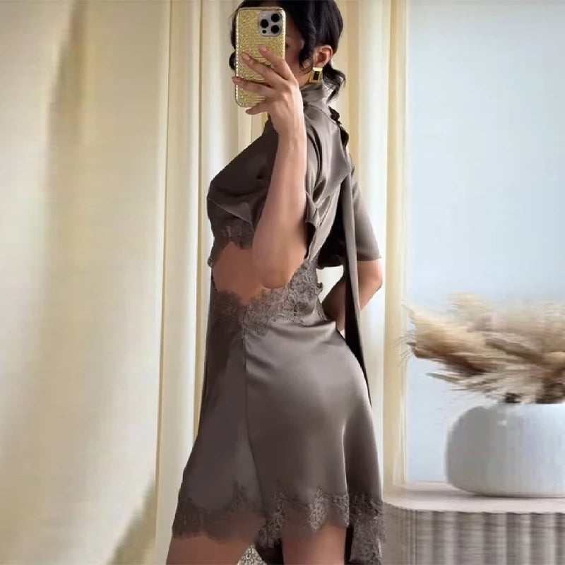 Person wearing a brown dress with lace details in a room.