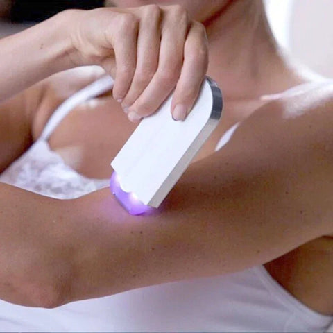 Person using a white electronic device with a purple light on their arm.