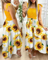 Woman wearing a yellow dress with sunflower pattern taking a mirror selfie.