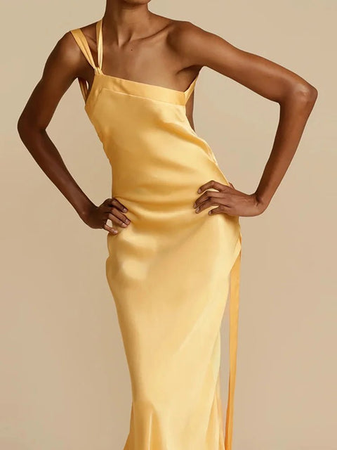 Woman wearing a yellow satin slip dress against a beige background