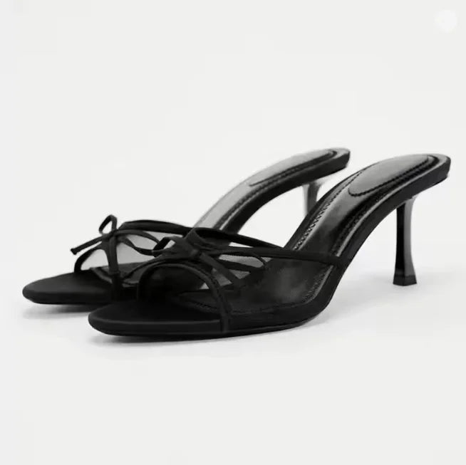 Black high-heeled sandals on a white background