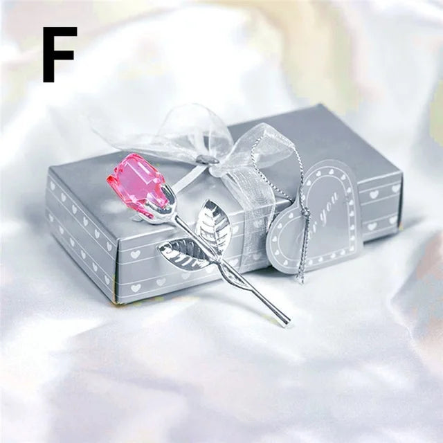 Silver rose with pink gem in a decorative box on a white background