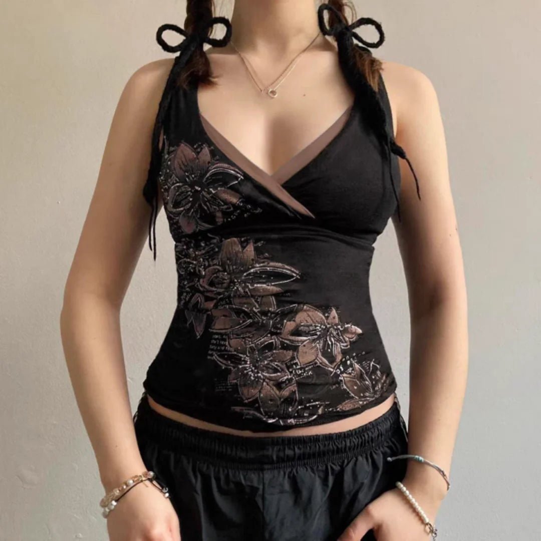 Black floral top worn by a person against a neutral background