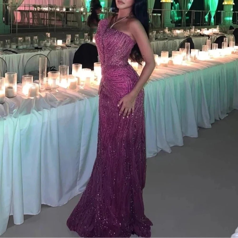 Woman in a purple evening gown standing in front of a decorated event setup with tables and candles.