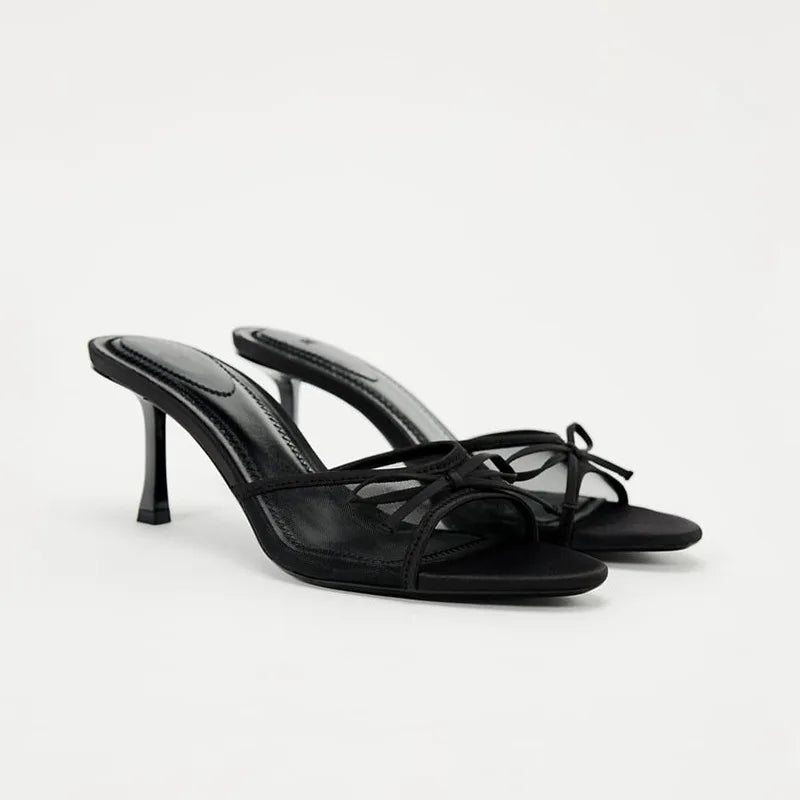 Black high-heeled sandals on a white background