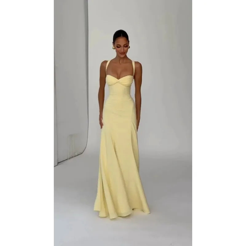 Woman wearing a yellow evening gown against a plain background