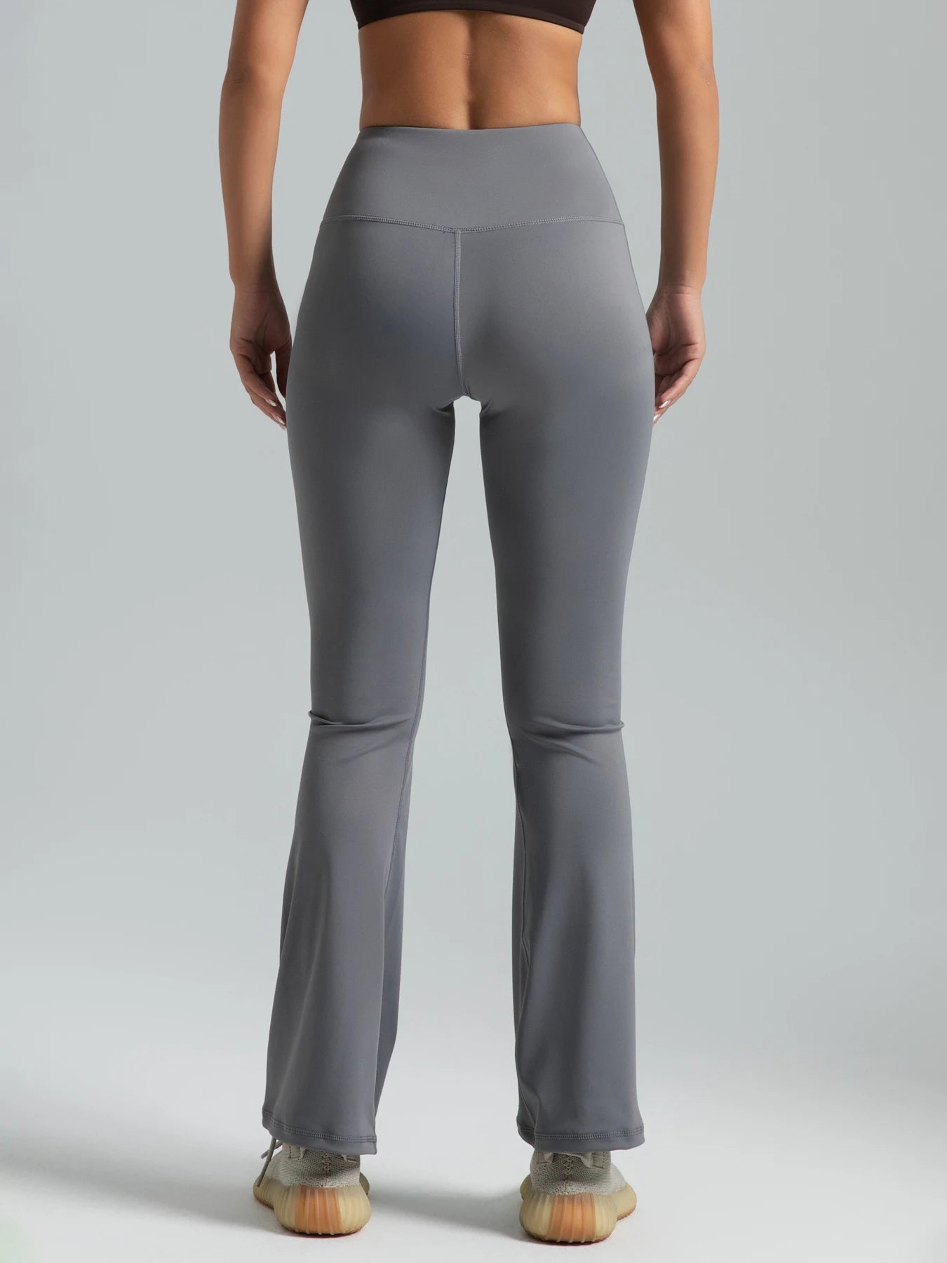 Person wearing gray high-waisted leggings on a plain background