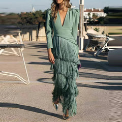 Woman wearing a green dress with fringe details outdoors.