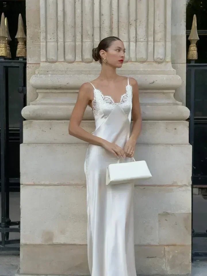 Woman in a white dress standing in front of classical architecture