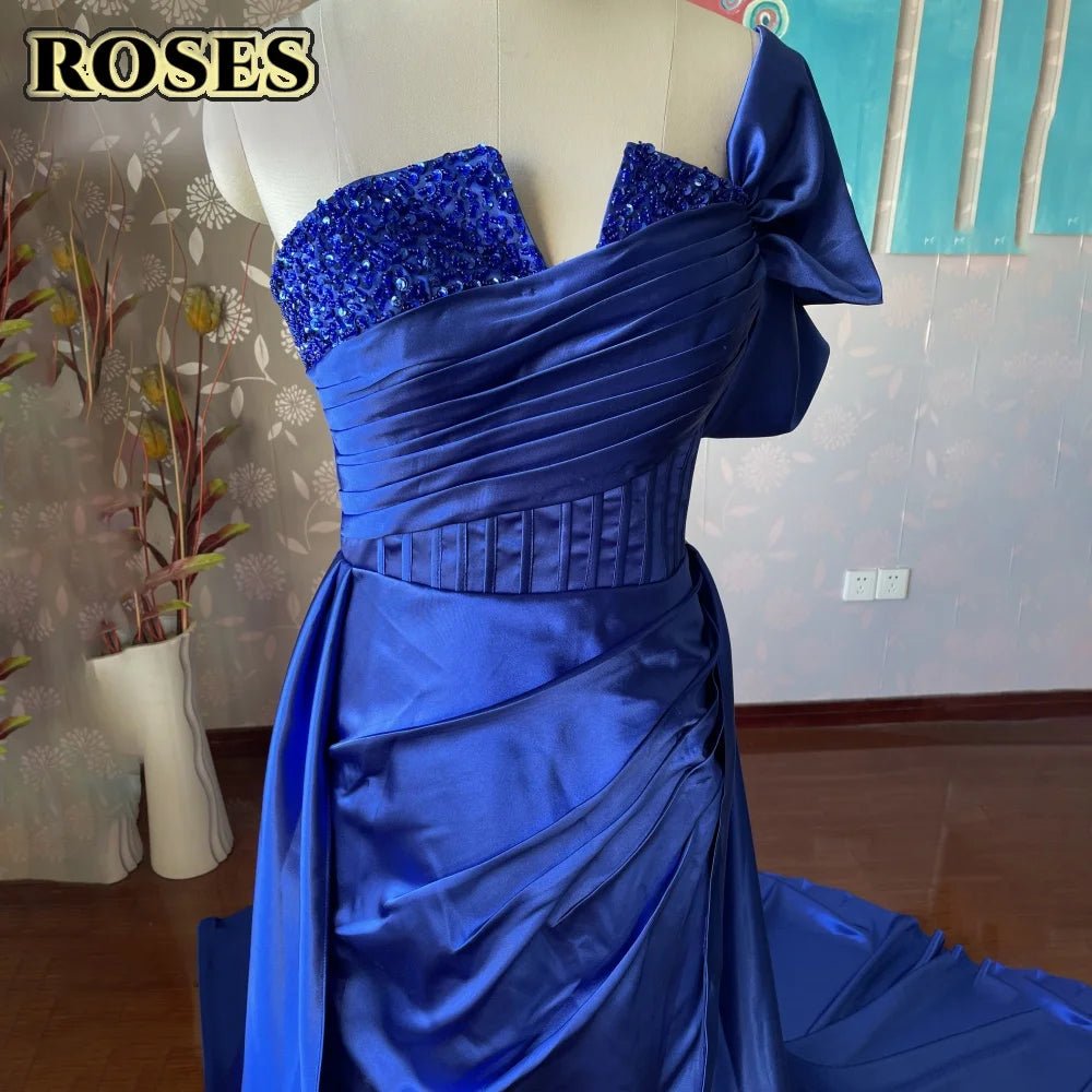 Blue evening gown on a mannequin against a neutral wall with 'ROSES' text.