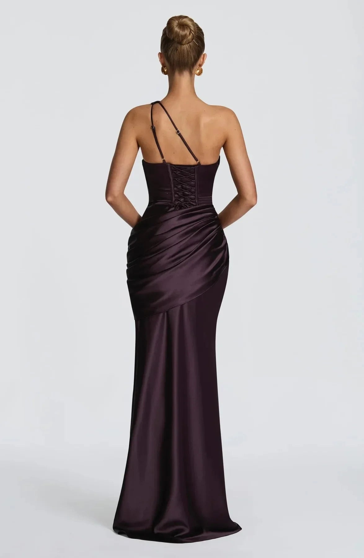 Woman wearing a dark purple evening gown on a white background