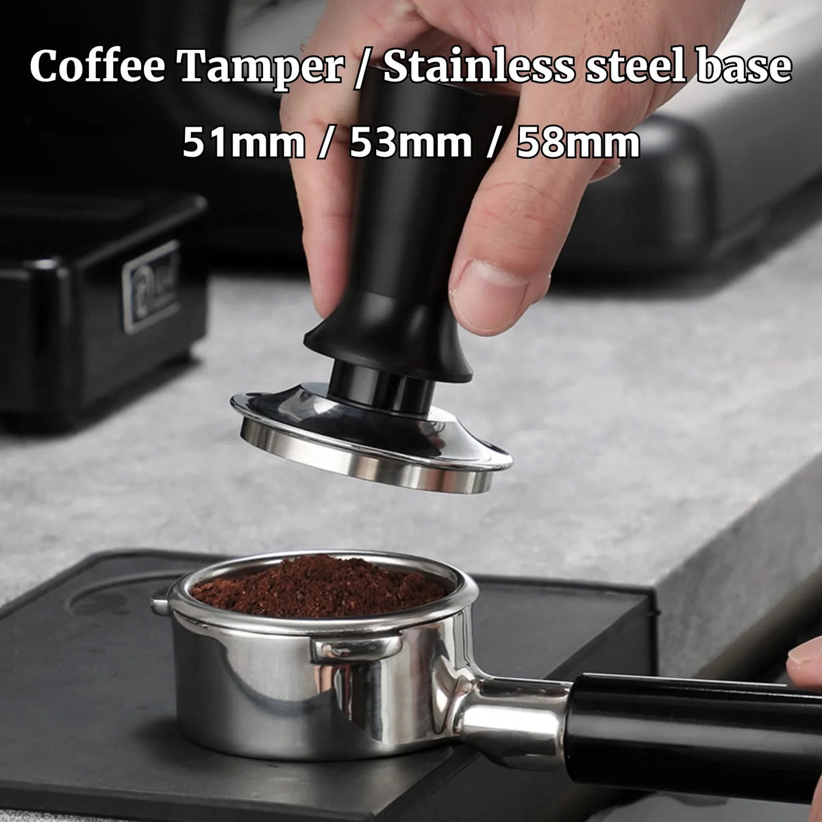 Coffee tamper with stainless steel base being used on a coffee grinder.
