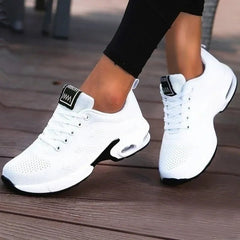 White sneakers with black accents on a wooden floor