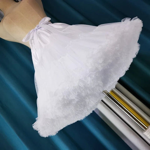 White lace-trimmed pillow on a blue surface with a window in the background