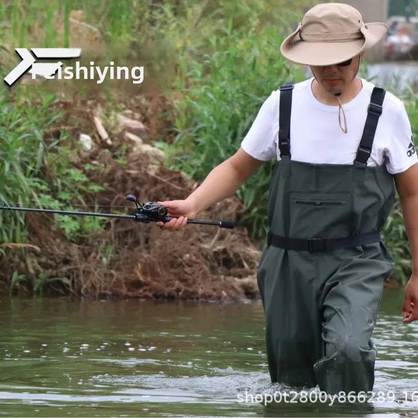 Person fishing in a river wearing a hat and waders with 'FISHIYING' branding.