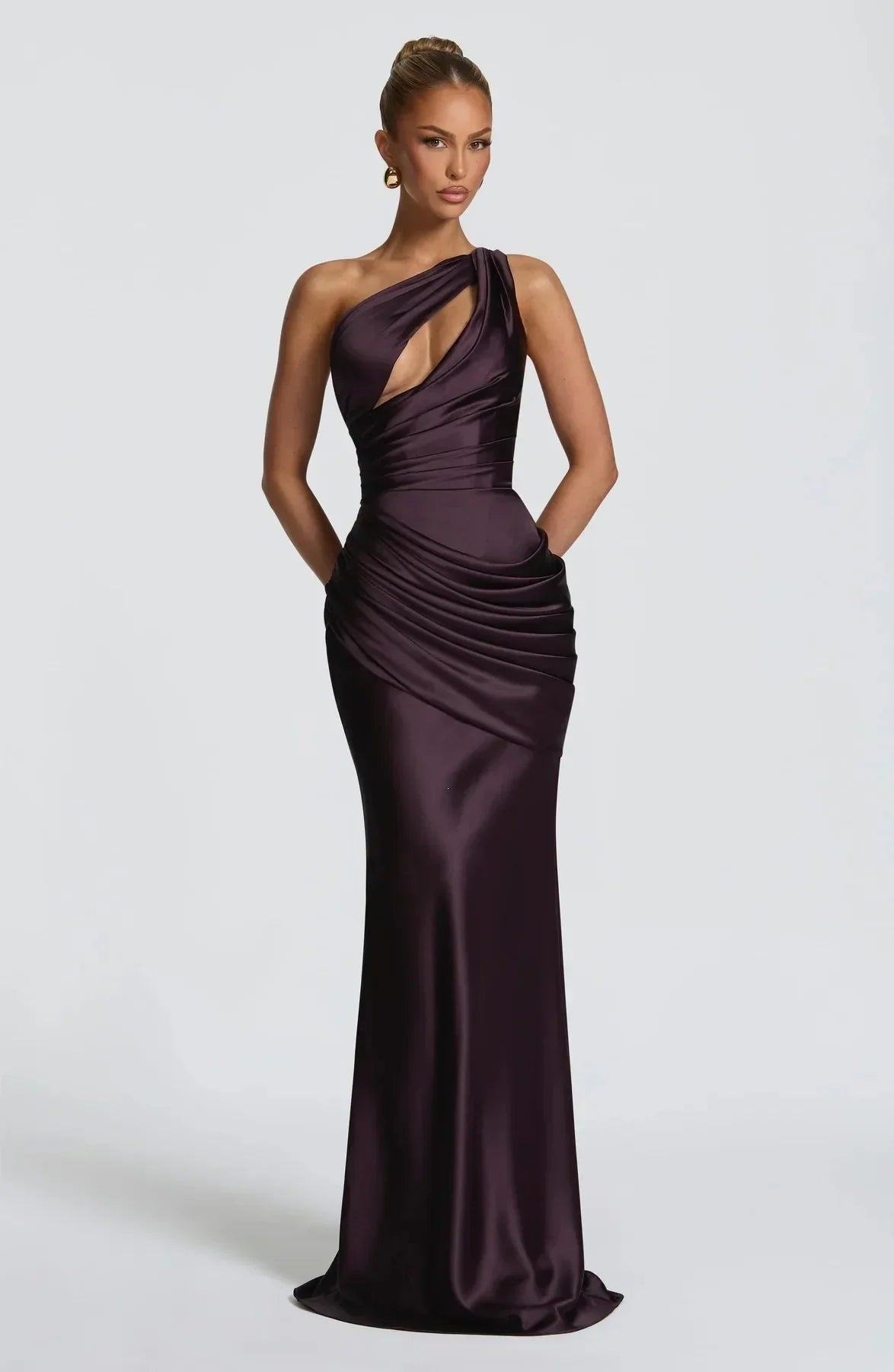 Woman wearing a one-shoulder purple evening gown on a white background