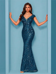 Woman wearing a blue sequin gown against a light blue background