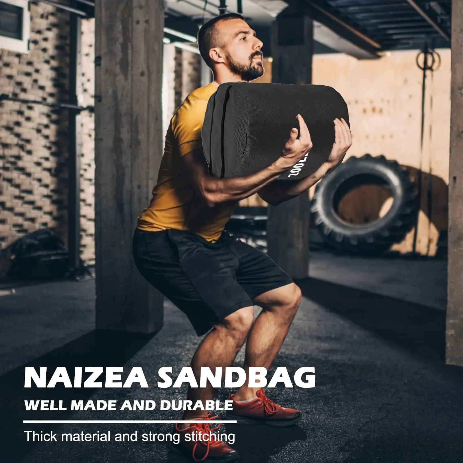 Man lifting a sandbag labeled 'NAIZEA SANDBAG' in an indoor gym setting.
