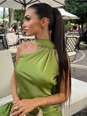 Woman in a green dress sitting outdoors with a blurred background