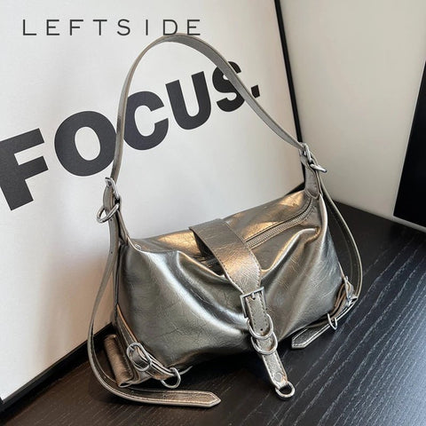 Silver handbag on a textured surface with 'LEFTSIDE FOCUS' text in the background