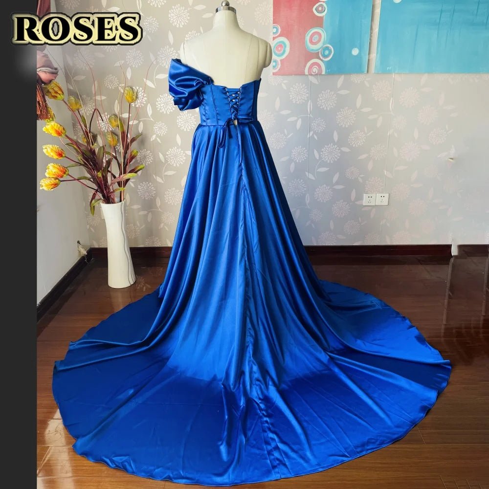 Blue evening gown on a mannequin against a wall with decorative elements.