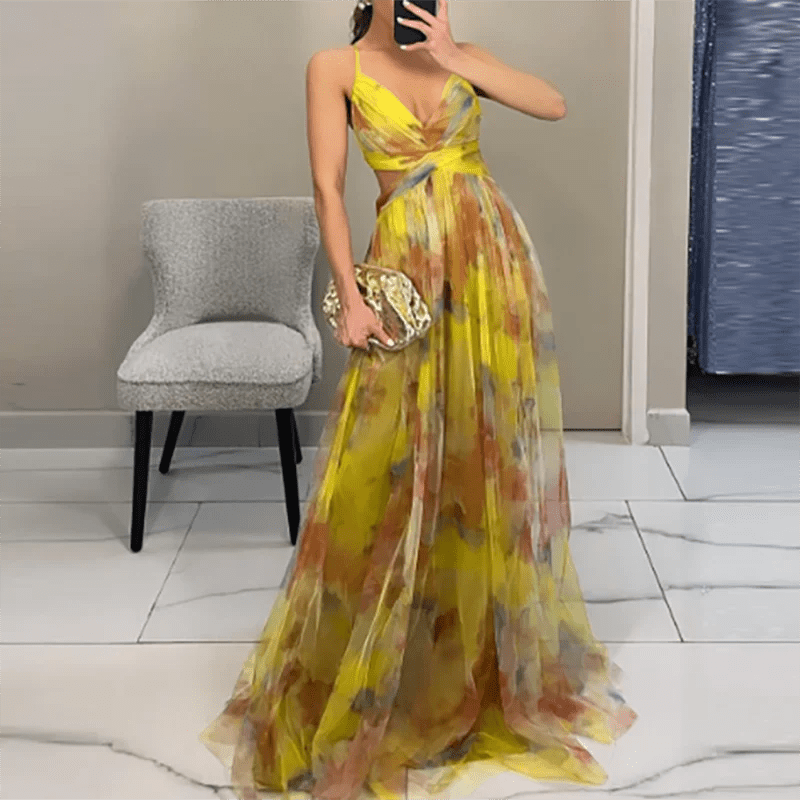 Woman in a colorful dress taking a mirror selfie in a room with a chair and door.