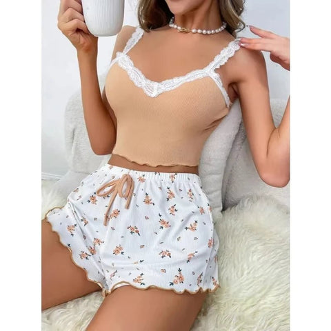 Woman wearing a beige lace top and white floral shorts, holding a mug.