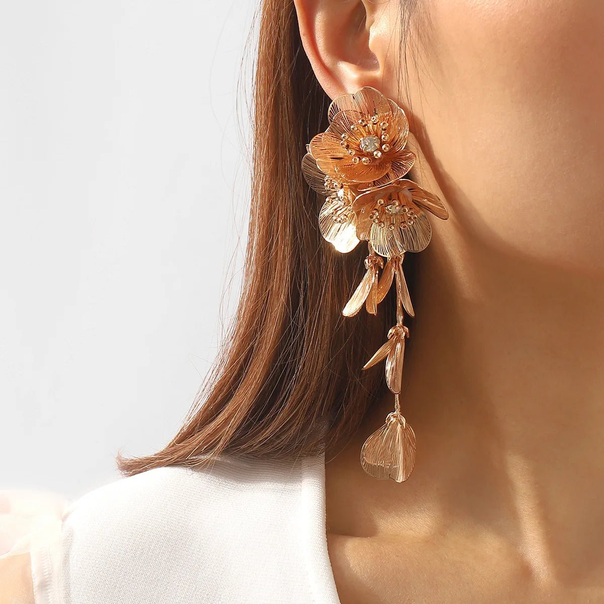 Close-up of a woman wearing a floral earring with a plain background