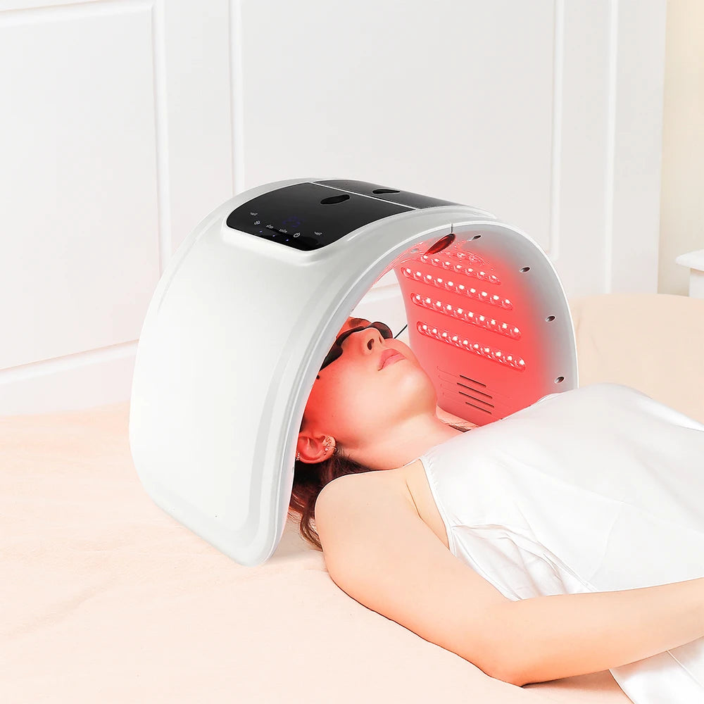 Person receiving LED light therapy on their face with a device.