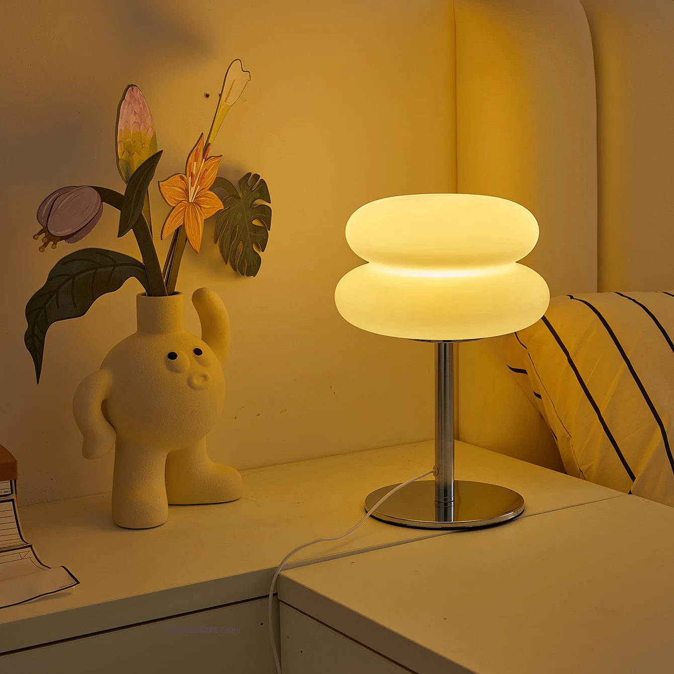 Table lamp on a desk with decorative items in a warm setting