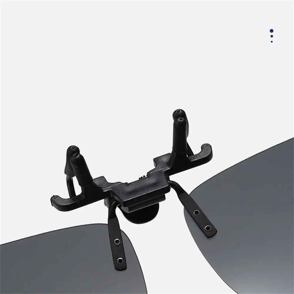 Black clip on a pair of sunglasses with a white background