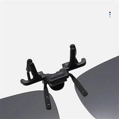 Black clip on a pair of sunglasses with a white background