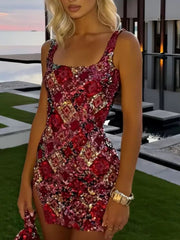 Woman wearing a red floral dress with a blurred outdoor background