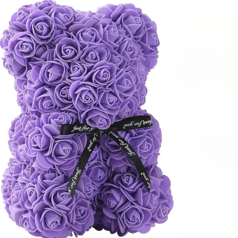 Purple rose teddy bear with a black ribbon on a white background