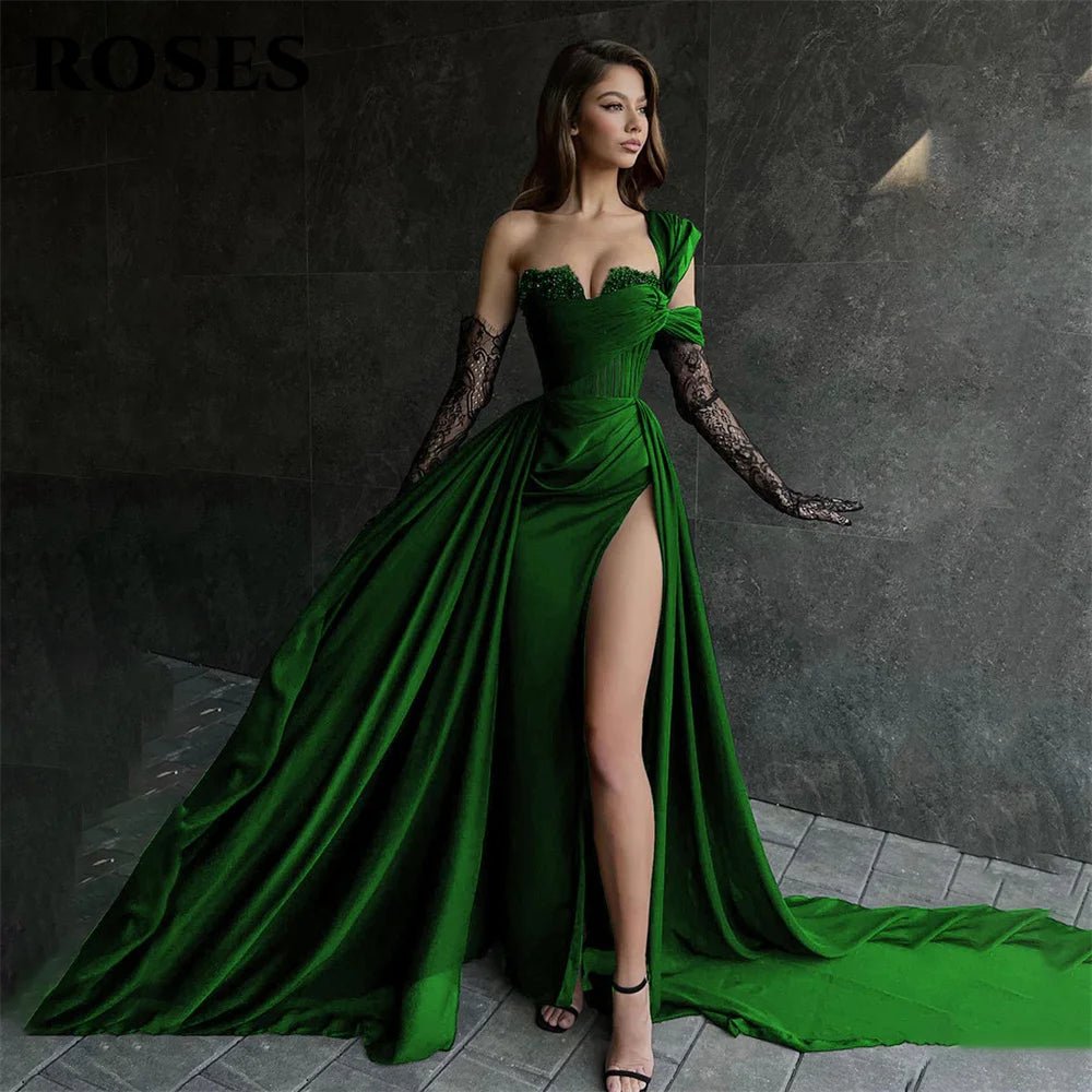Woman in a green evening gown with a high slit on a dark background