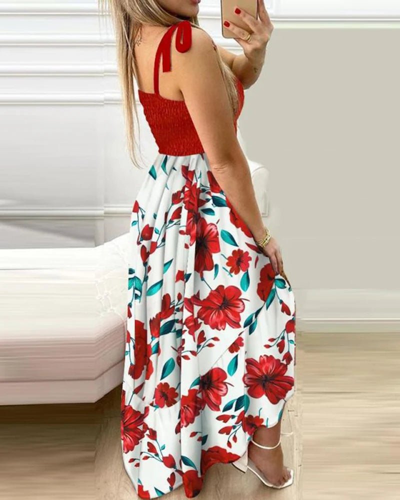Woman wearing a red top and floral dress taking a selfie indoors.
