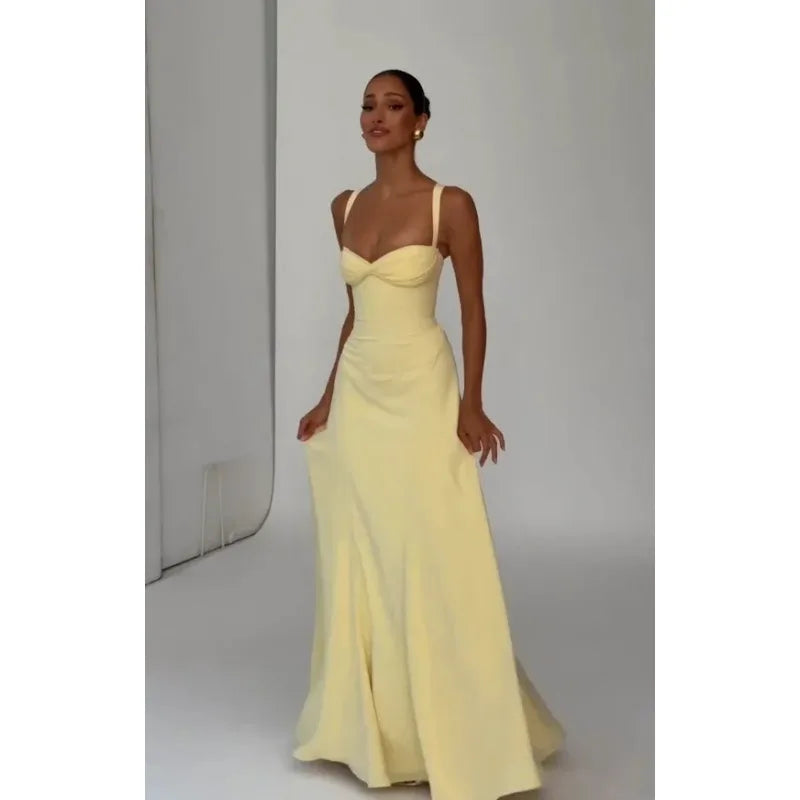Woman wearing a yellow evening gown against a plain background