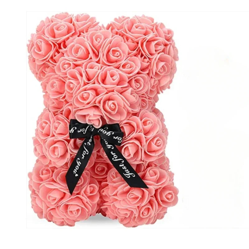 Pink teddy bear made of roses with a black ribbon on a white background