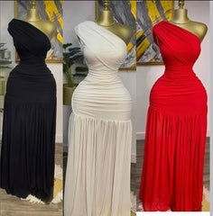 Three mannequins wearing black, white, and red one-shoulder evening gowns in a room setting.