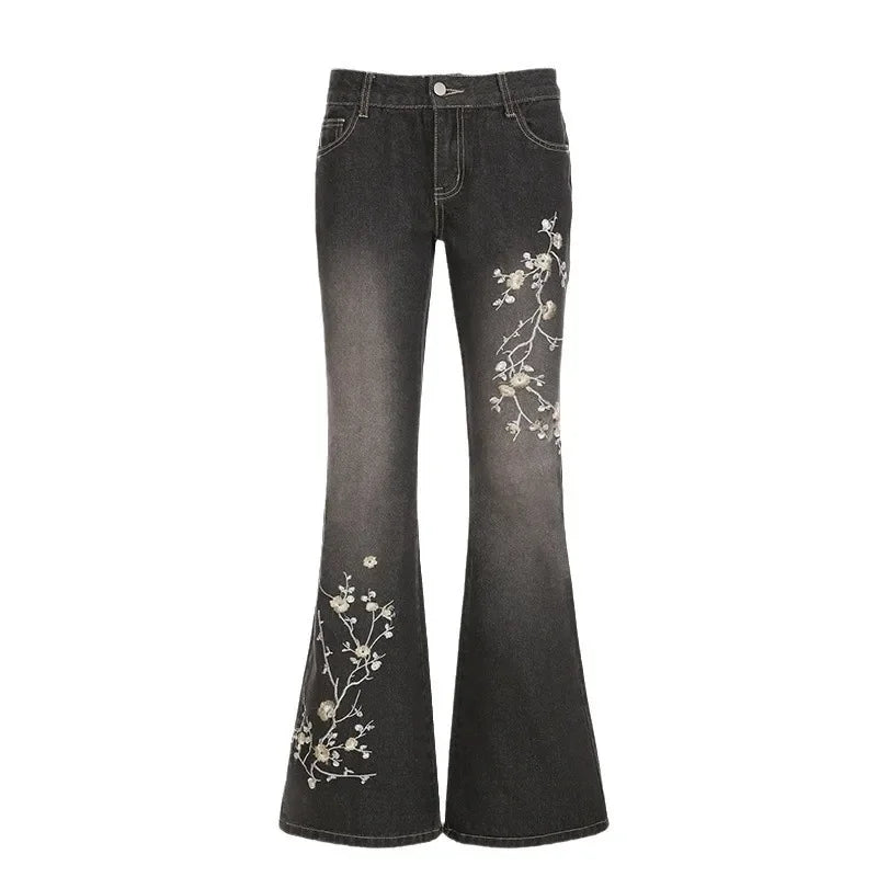 Black flared jeans with floral embroidery on a white background
