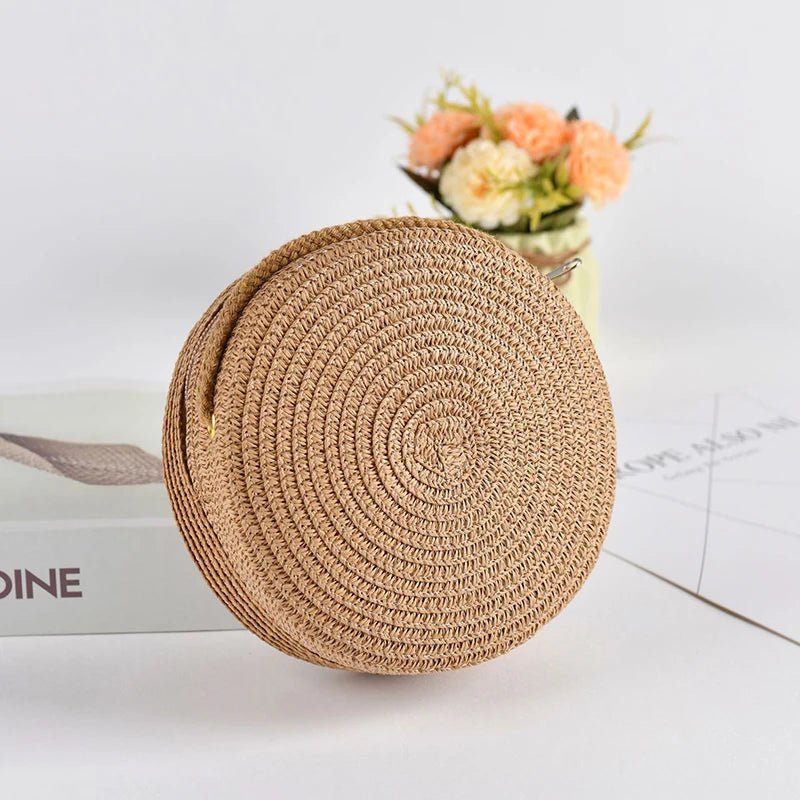 Round woven straw bag on a light surface with a blurred background